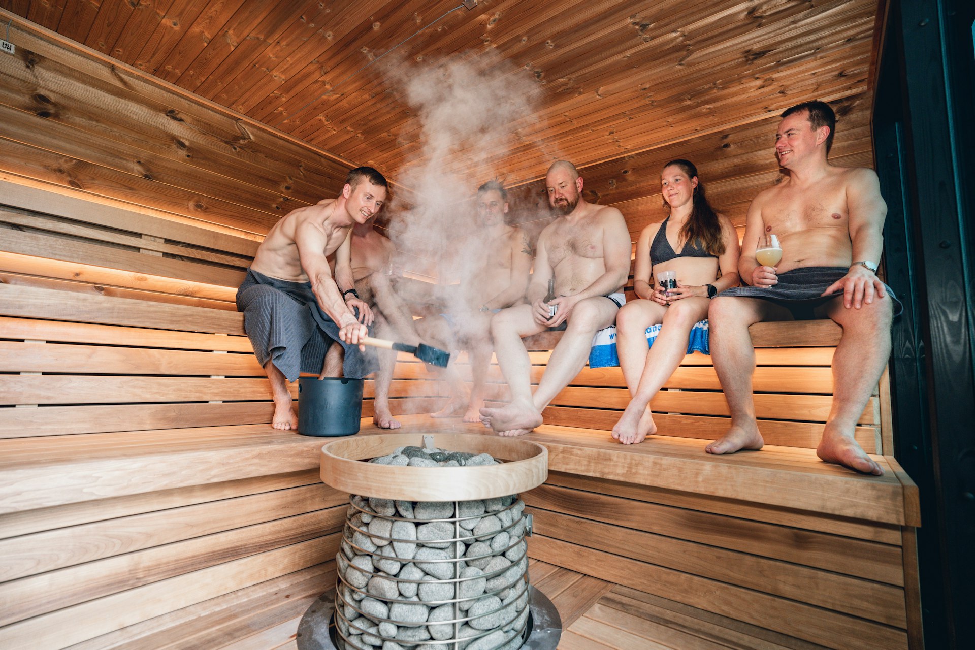 Steamy wooden indoor sauna with heater stones