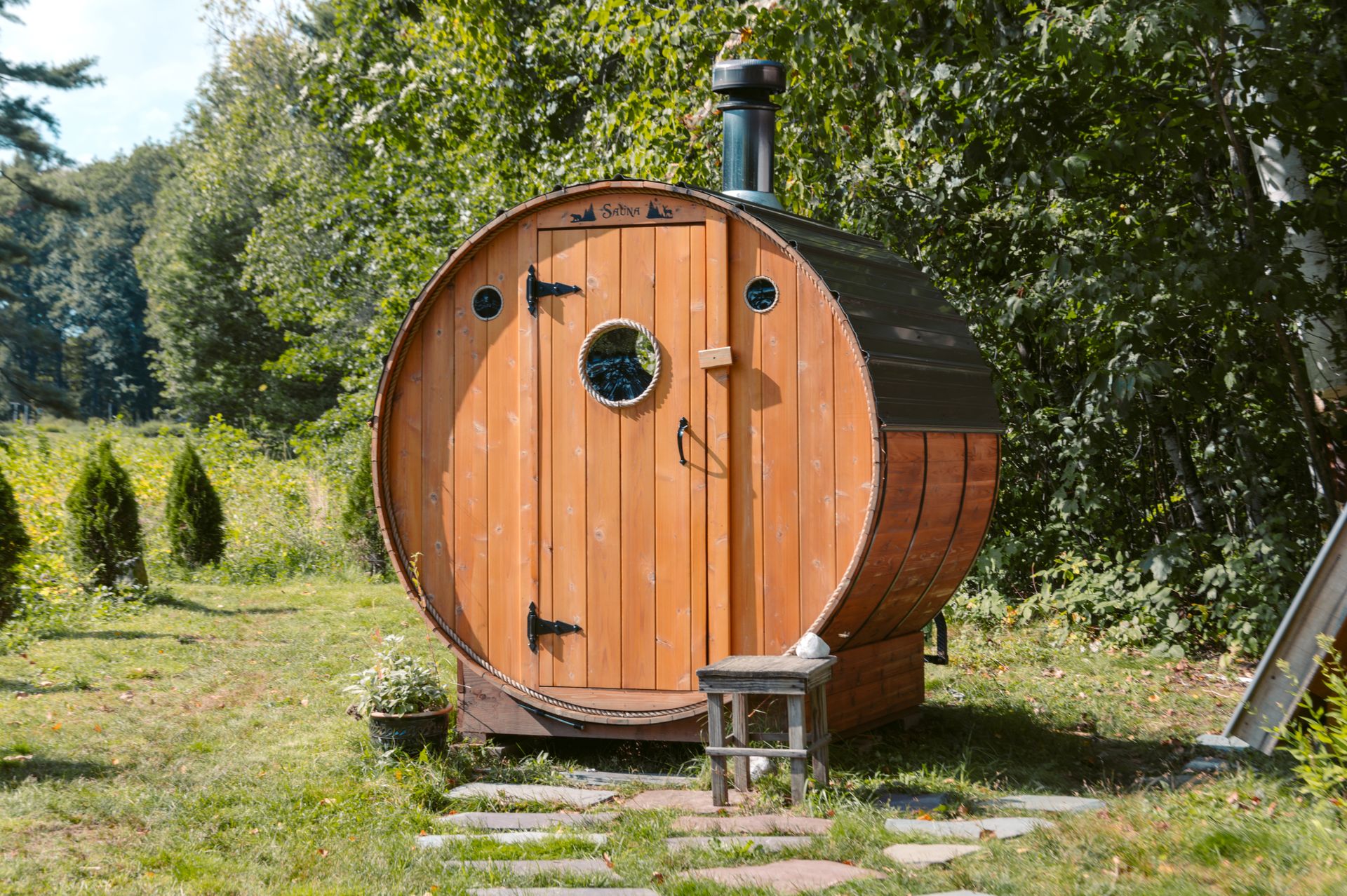 Outdoor wooden barrel sauna in a garden setting
