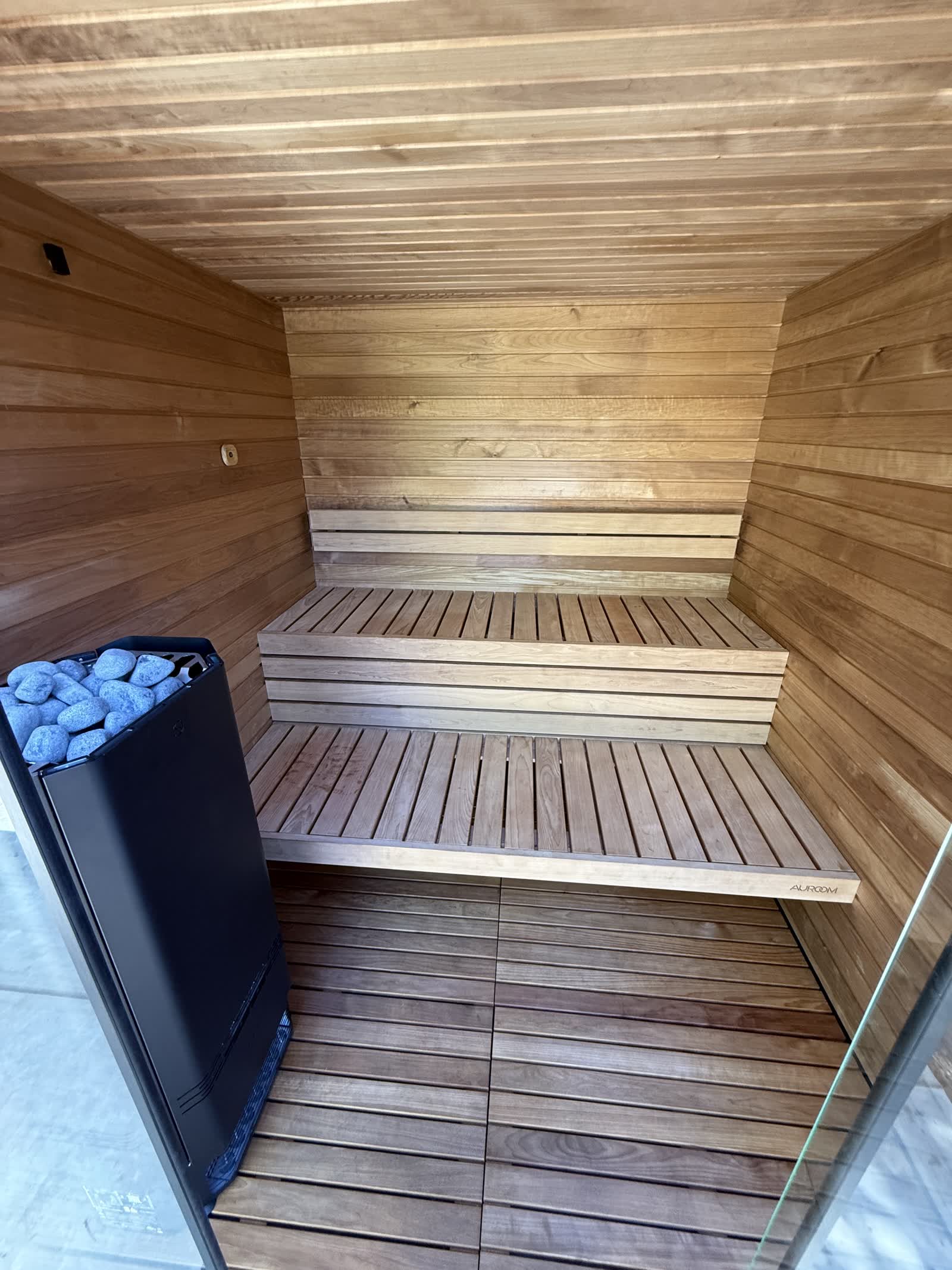 Auroom sauna interior with black heater and tiered benches Orangevale CA