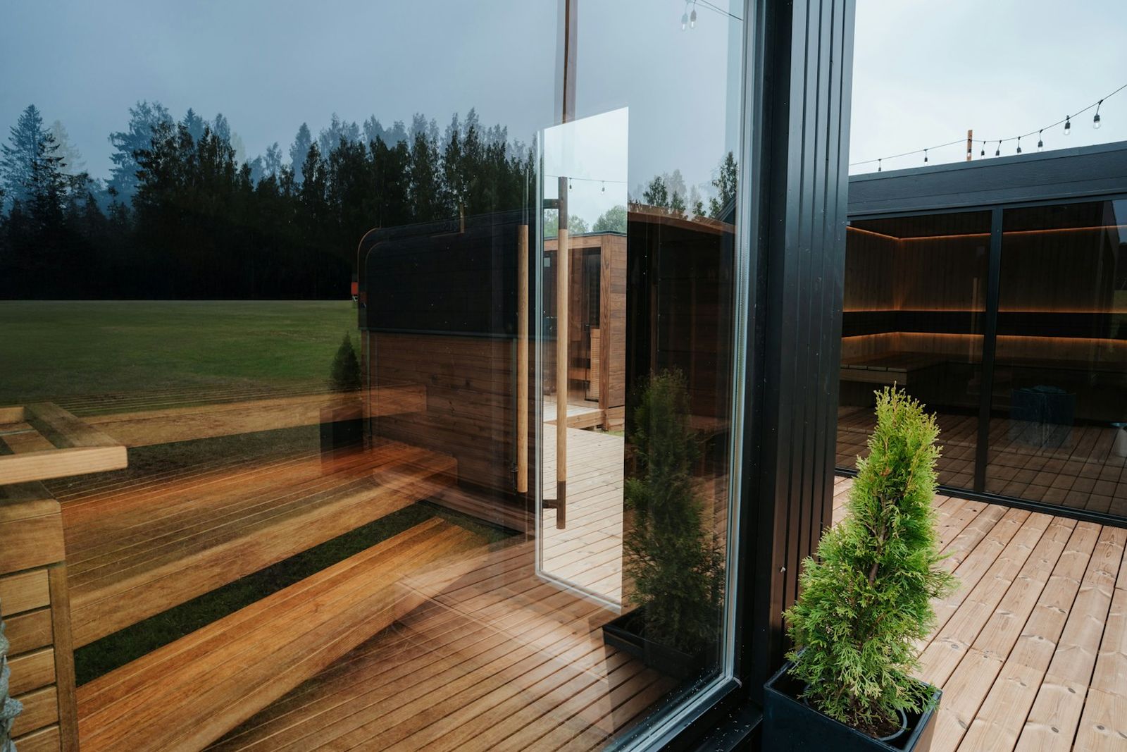 Premium outdoor glass-front sauna with warm cedar benches and deck lighting - Sierra Sauna Co. shop showcase